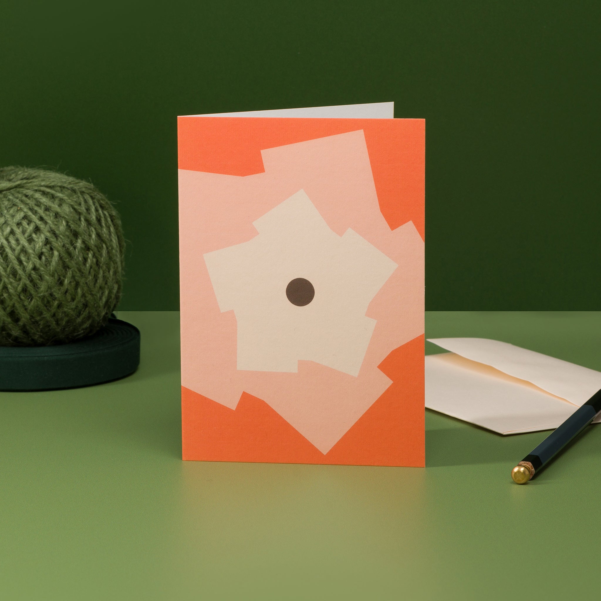 Orbit 3 greeting card in orange, with cog-like motifs circling a central disc.