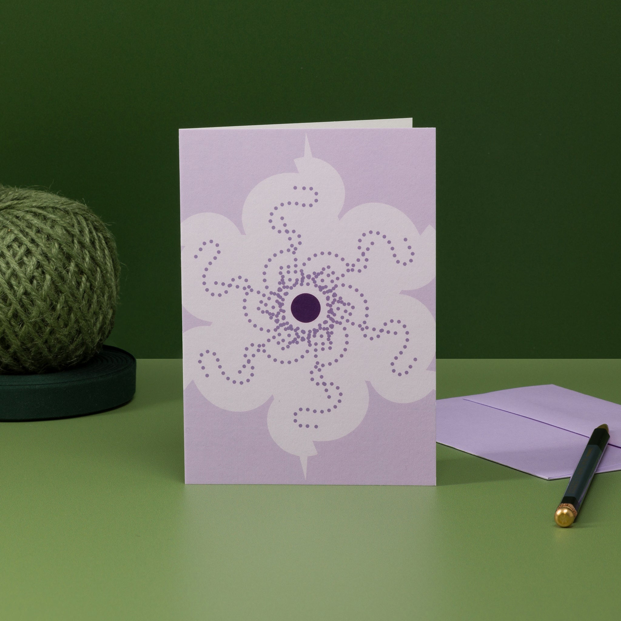 Orbit 2 greeting card, lilac colour scheme and matching envelope. Design: geometric floral motif with central disc