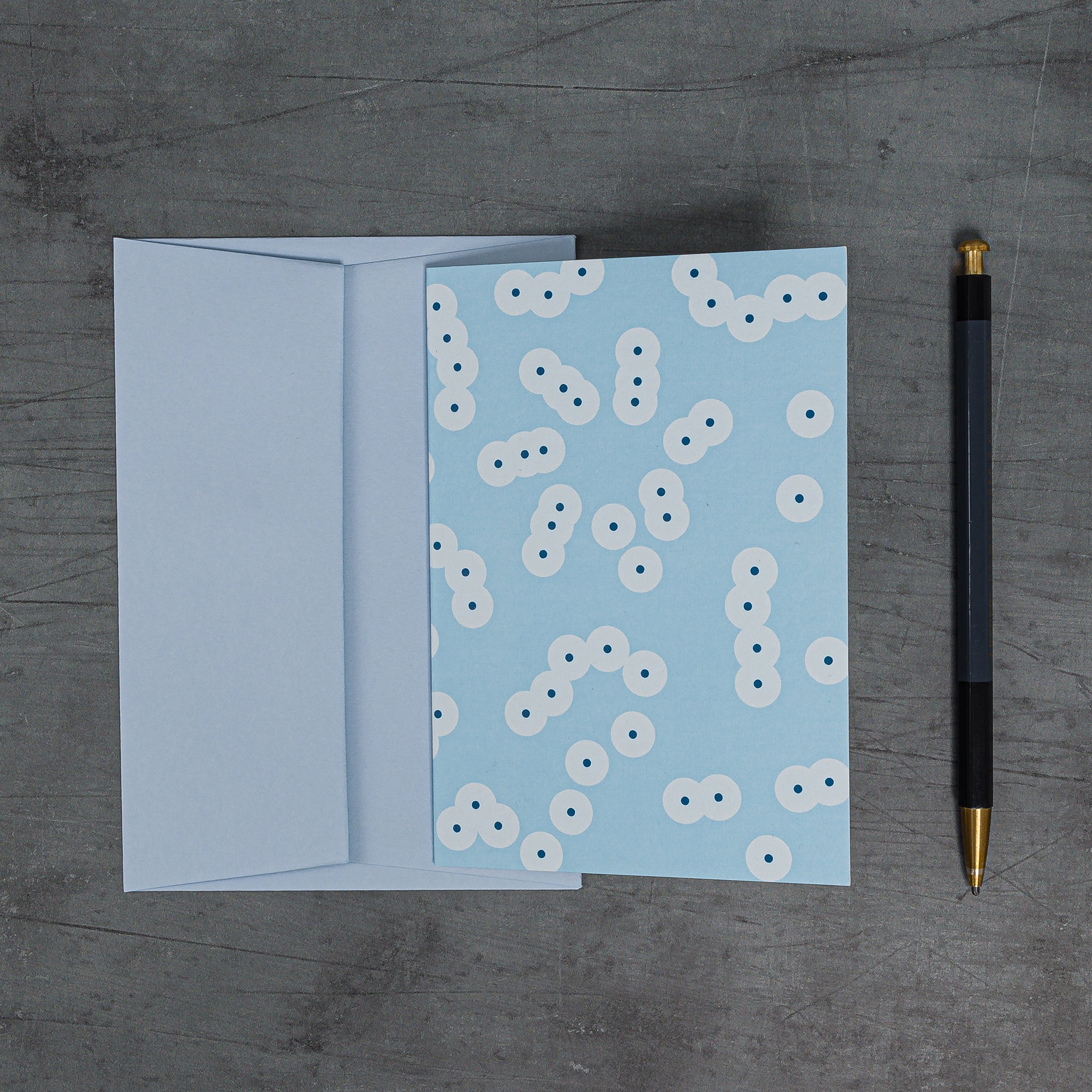 Stack (blue) greeting card with coordinating pale blue envelope. Pattern: clusters of circle motifs, redolent of frog spawn