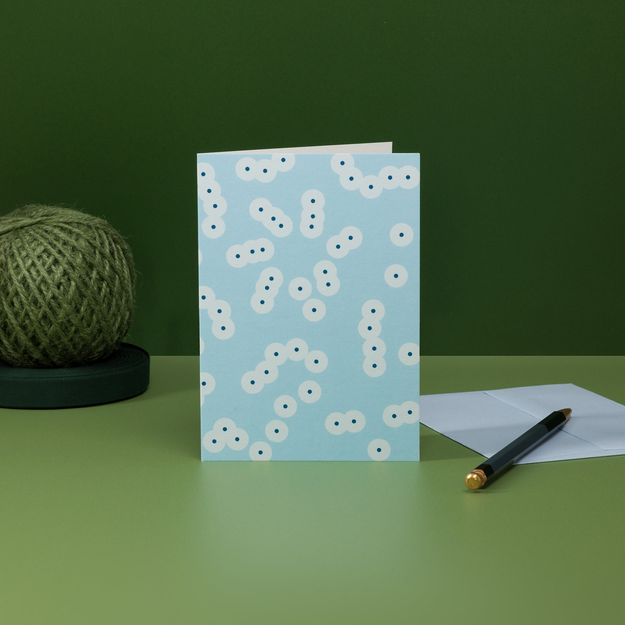 Stack (blue) greeting card and pale blue G F Smith envelope. Irregular pattern of clustered circle motifs, inspired by frog spawn