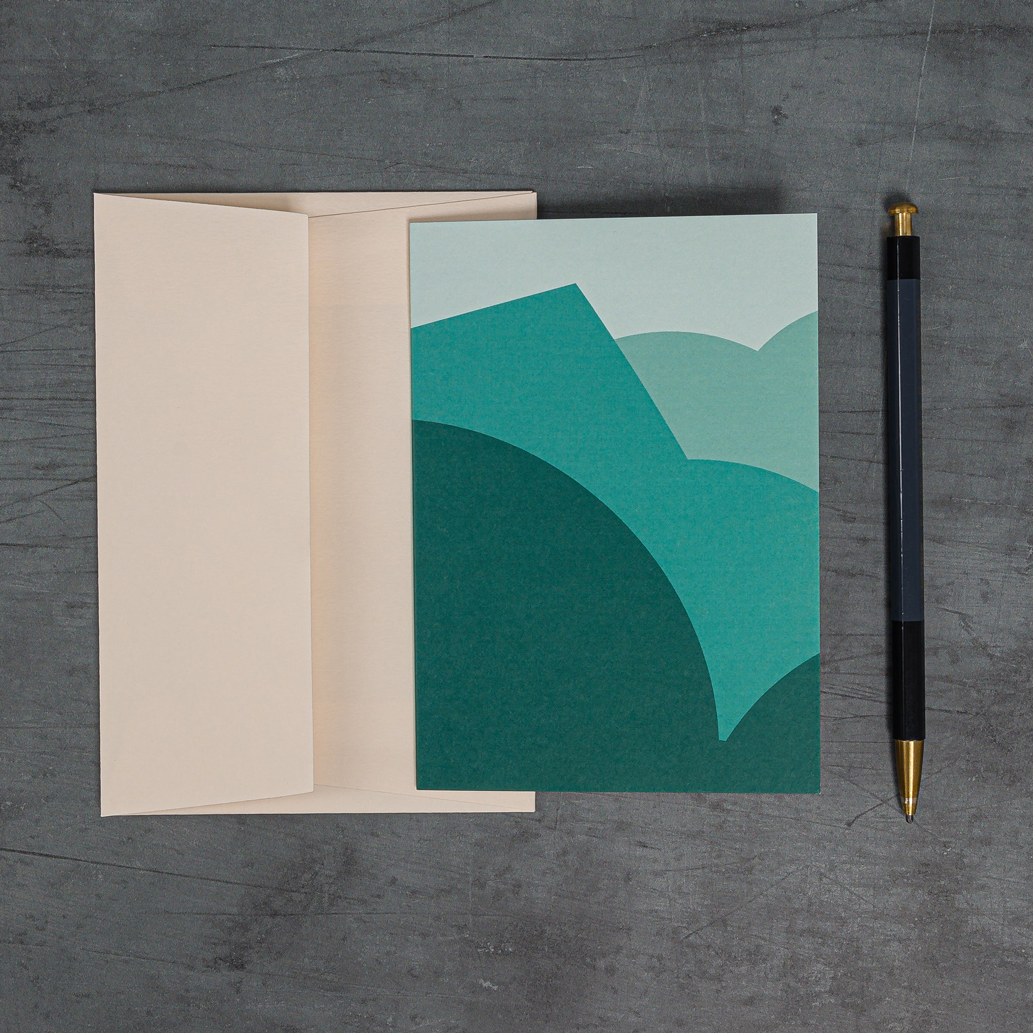 Aerial view of Stack (teal) greeting card - Stacked curves and angles suggestive of landscape, in rich teal tones. Shown with coordinating peach-coloured envelope