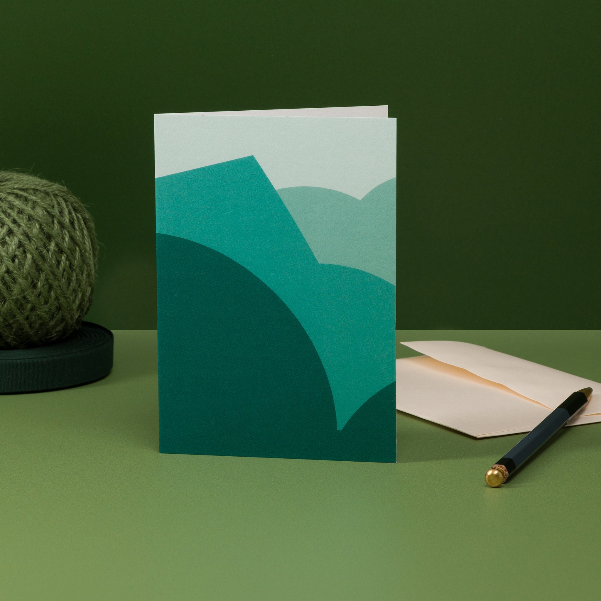 Stack (teal) greeting card - geometric design of stacked curves and angles, suggestive of a landscape. Teal colour scheme with dark tones at the base, graduating to pale at the top of the design