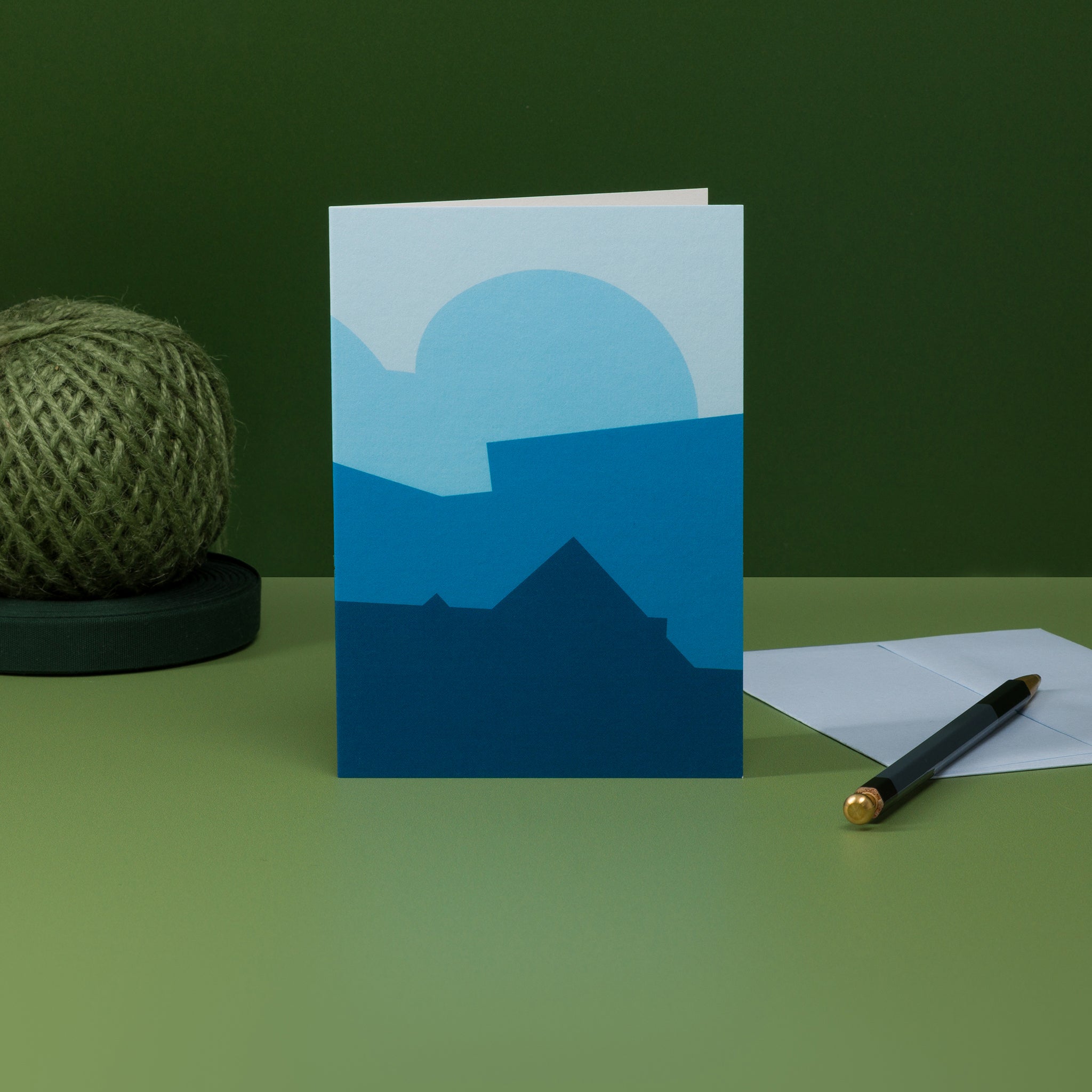 Stack (blue) greeting card with matching G F Smith envelope in pale blue. Design  of stacked geometric shapes resembles a schematised natural landscape as well as architecture